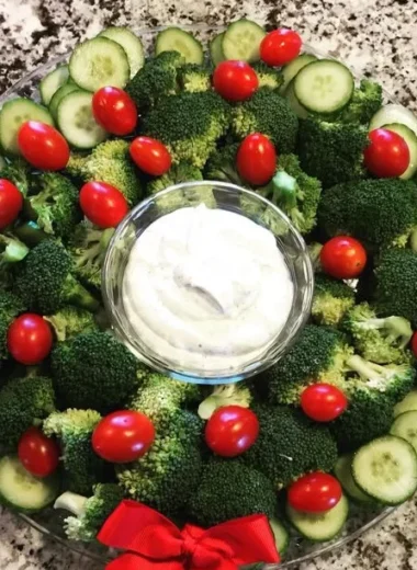Colorful Christmas veggie wreath appetizer with fresh vegetables and herbs.