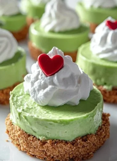 Festive Grinch Mini Cheesecake topped with green frosting and red decorations