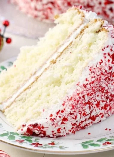 Delicious holiday peppermint cake topped with whipped cream and candy canes.