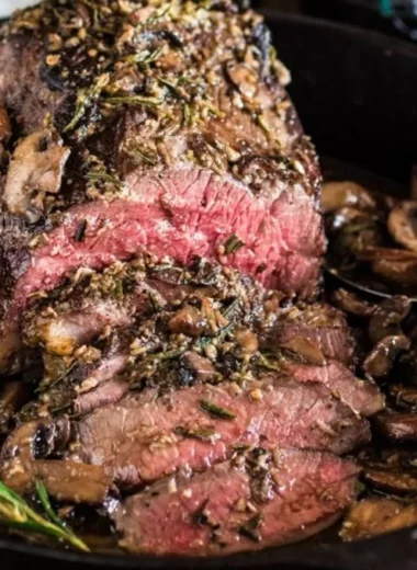 Rosemary and Garlic Roast Beef served on a platter with herbs