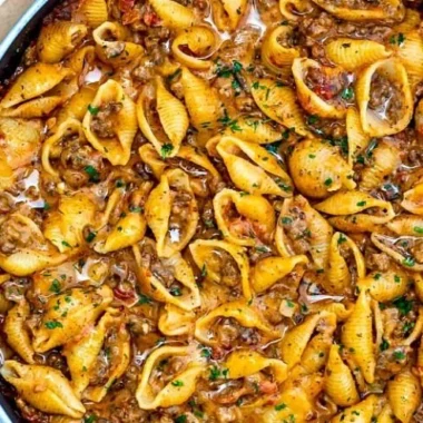 Creamy beef and shell pasta topped with cheese, ready to serve.