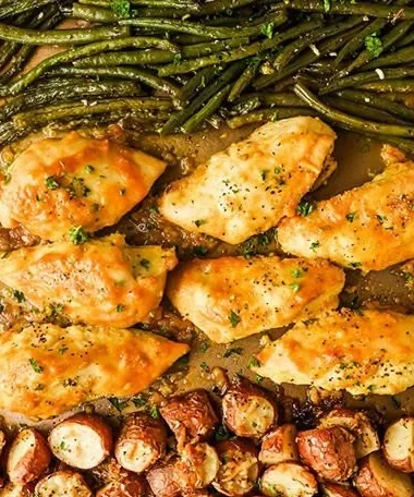 Plate of delicious chicken breast recipes with colorful sheet pan vegetables.