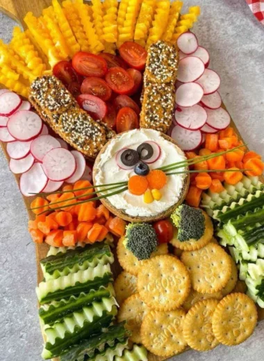 Easter veggie charcuterie board with vibrant vegetables and colorful dips